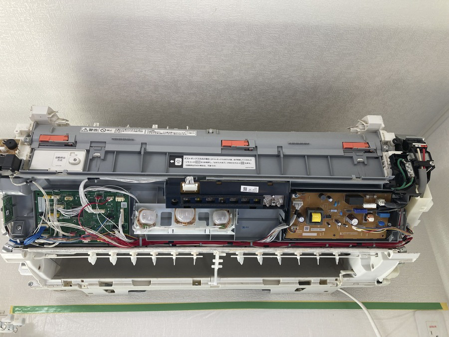 お掃除ユニットや基板パーツを取り外したお掃除機能付きエアコンの分解作業風景